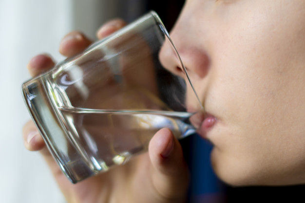 close up teenager drinking pure water from glass